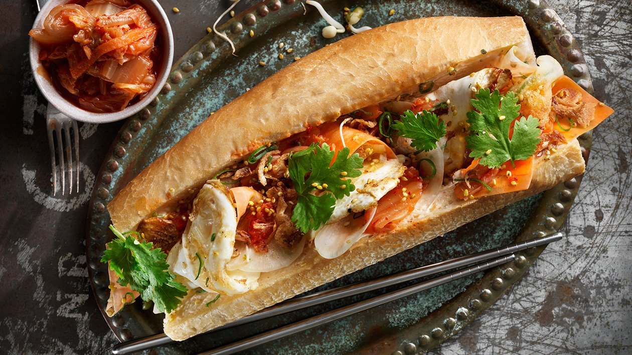 Banh mi med spejlæg, røget chilimayonnaise, kimchi og kinaradise. Banh mi med spejlæg, røget chilimayonnaise, kimchi og kinaradise.