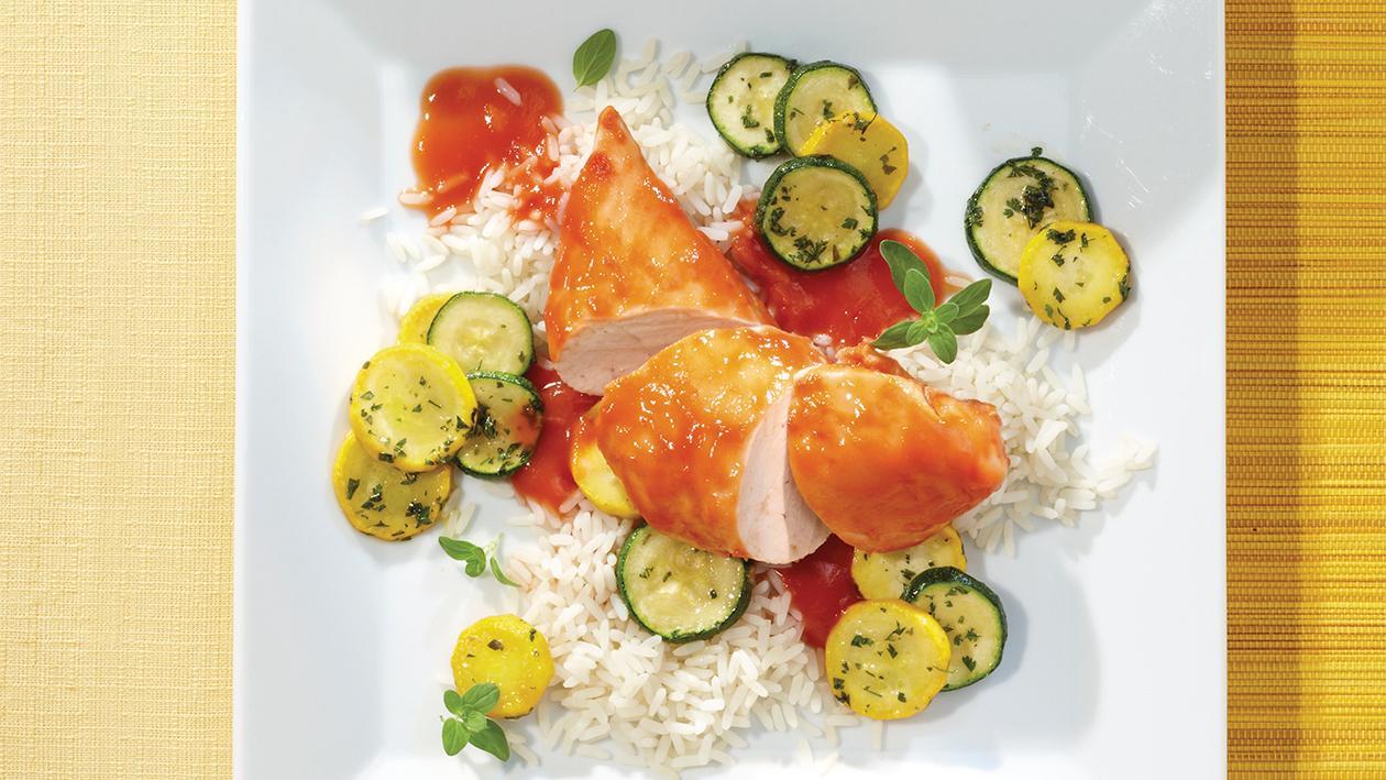 In Tomatensauce pochiertes Hähnchenbrustfilet mit Zucchini-Gemüse und Reis In Tomatensauce pochiertes Hähnchenbrustfilet mit Zucchini-Gemüse und Reis