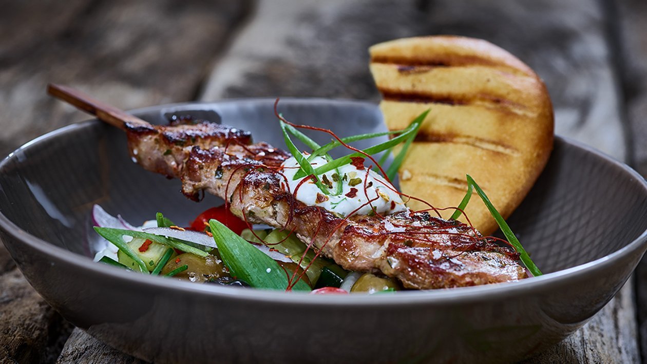 Schweinesouvlaki im Pitabrot mit Tzaziki und griechischem Salat Schweinesouvlaki im Pitabrot mit Tzaziki und griechischem Salat