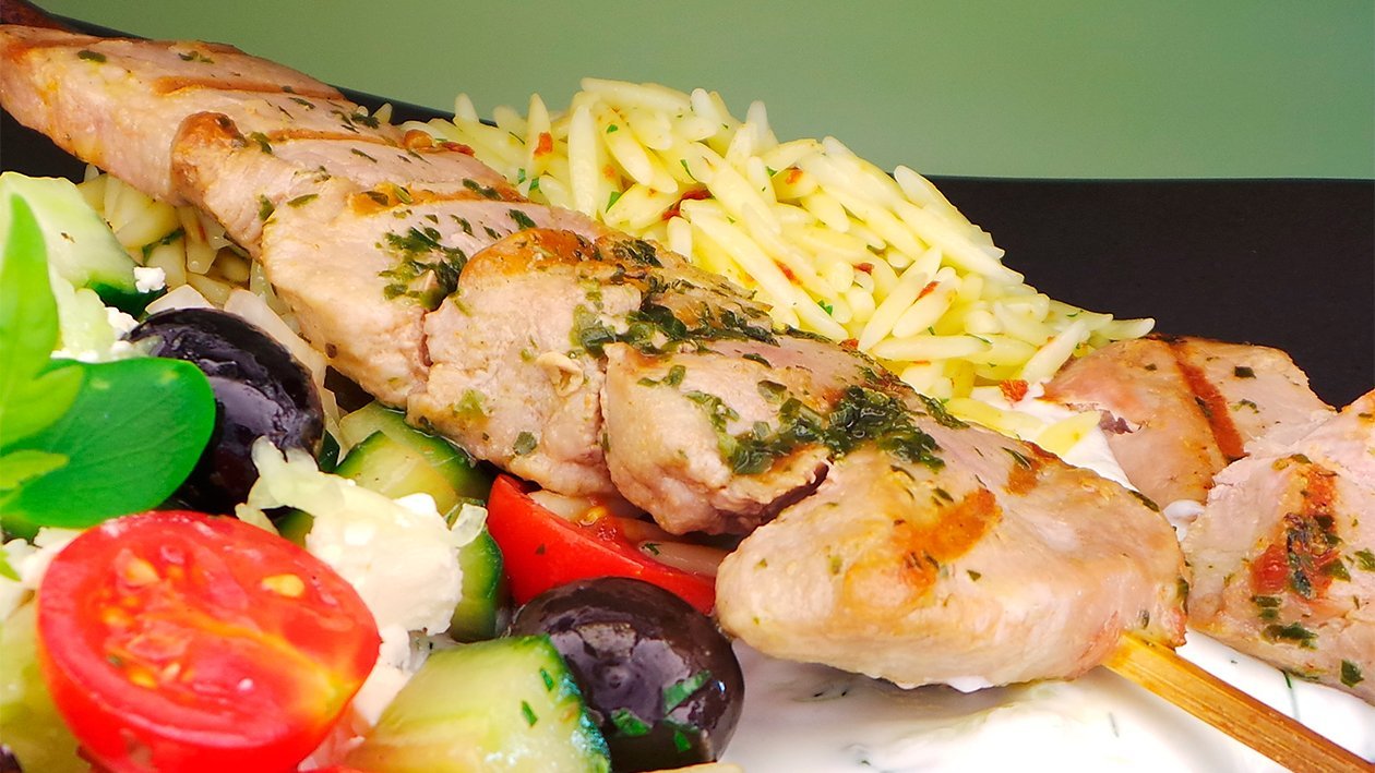Schweinespieße mit Tzaziki, Kritharaki Nudeln und griechischem Salat Schweinespieße mit Tzaziki, Kritharaki Nudeln und griechischem Salat