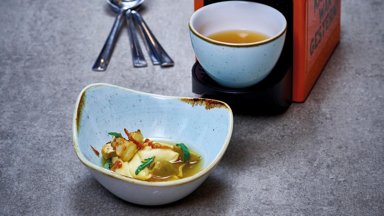 Tomaten-Consommé mit Tortellini, Artischocken, Oliven und Rucola Tomaten-Consommé mit Tortellini, Artischocken, Oliven und Rucola
