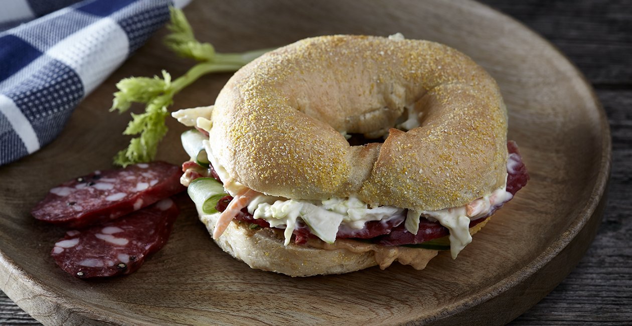 Bagel με Αρωματικό Dressing Μουστάρδας, Σαλάμι Λευκάδος και Φλέικς Γραβιέρας Bagel με Αρωματικό Dressing Μουστάρδας, Σαλάμι Λευκάδος και Φλέικς Γραβιέρας