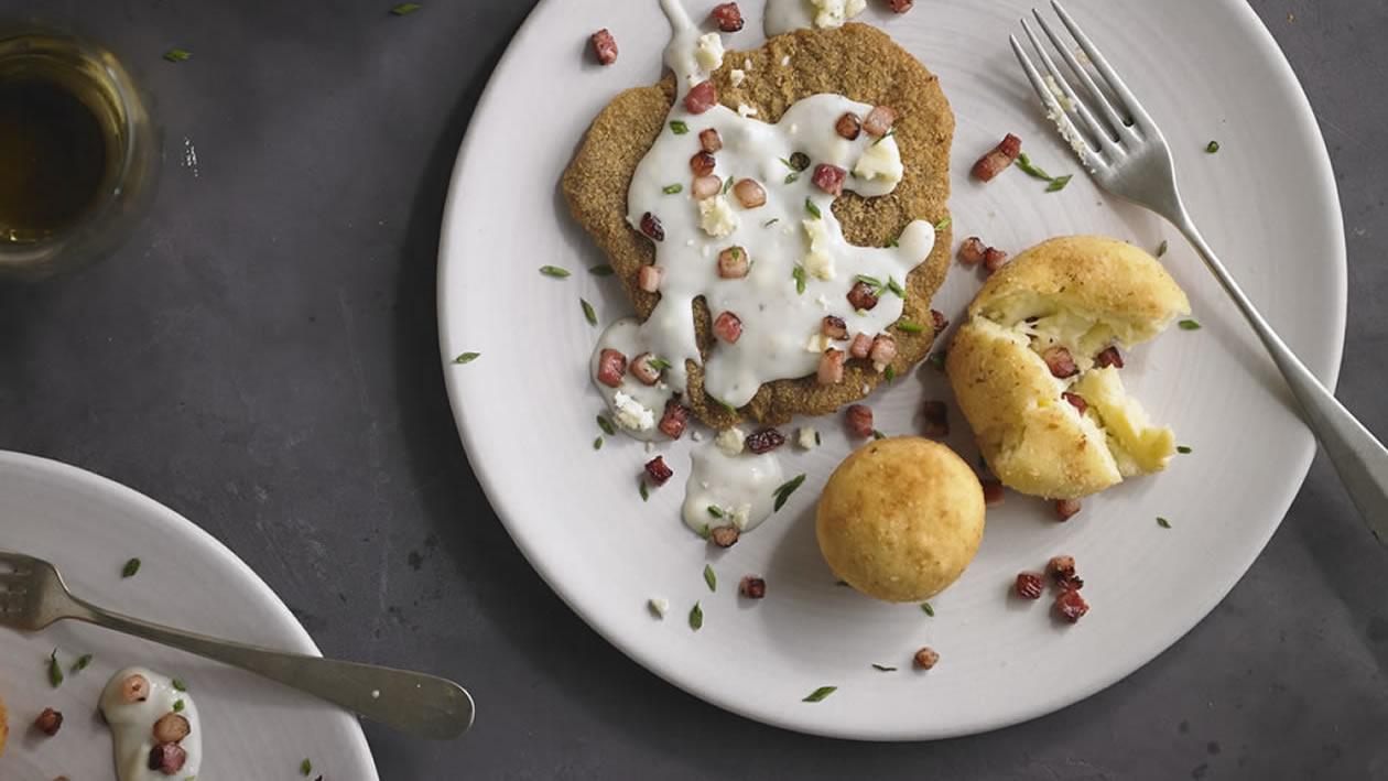 Milanesa con salsa de queso azul y bombas de papa Milanesa con salsa de queso azul y bombas de papa
