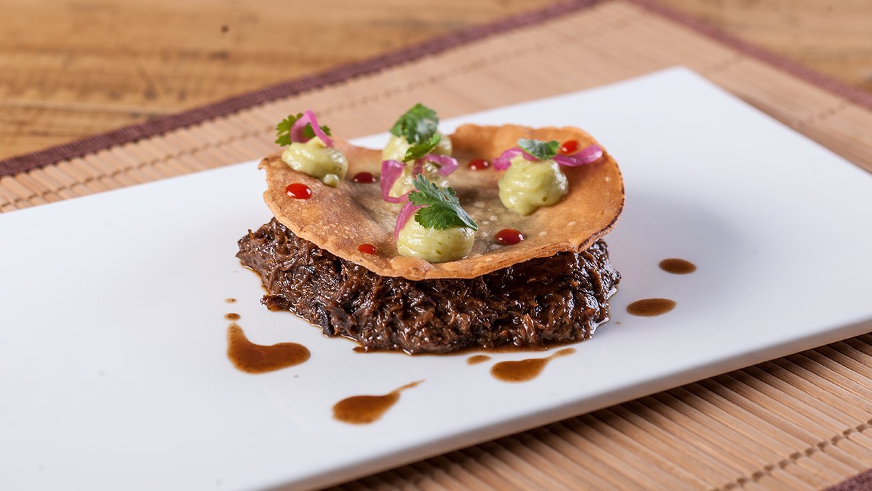 Carrillera de ternera guisada con tortilla de maíz crujiente y guacamole Carrillera de ternera guisada con tortilla de maíz crujiente y guacamole