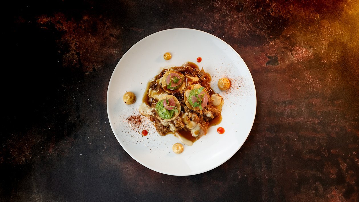Costilla de cerdo con crema de ibérico, maíz crujiente, guacamole y encurtidos Costilla de cerdo con crema de ibérico, maíz crujiente, guacamole y encurtidos
