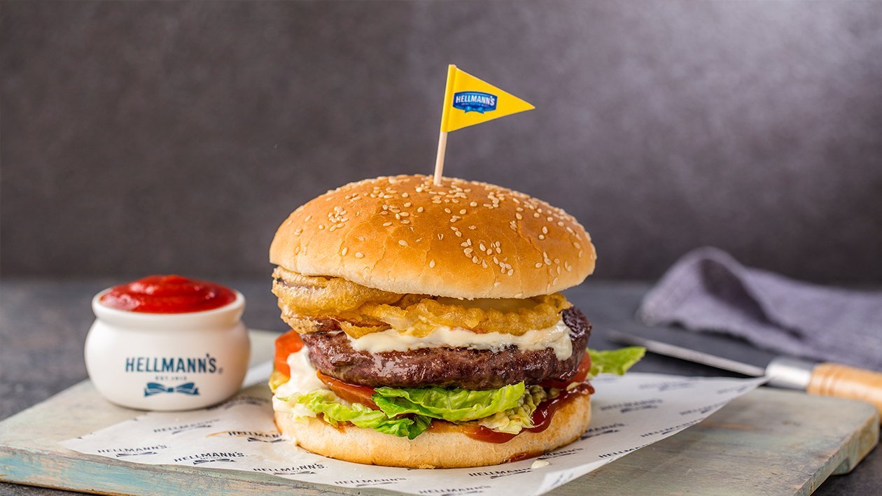Hamburguesa de ternera fundida de quesos, salsa barbacoa y aros de cebolla Hamburguesa de ternera fundida de quesos, salsa barbacoa y aros de cebolla