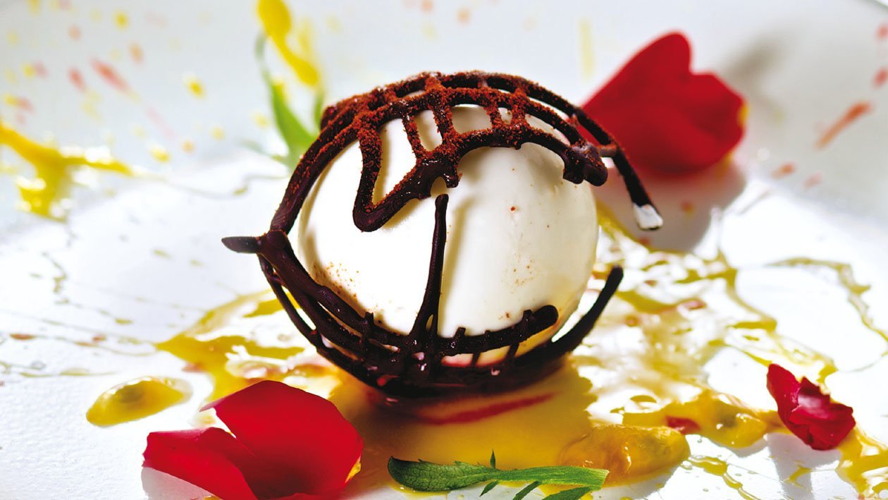 Panna cotta a base de guindilla y chocolate crujiente sobre puré de fruta de la pasión Panna cotta a base de guindilla y chocolate crujiente sobre puré de fruta de la pasión