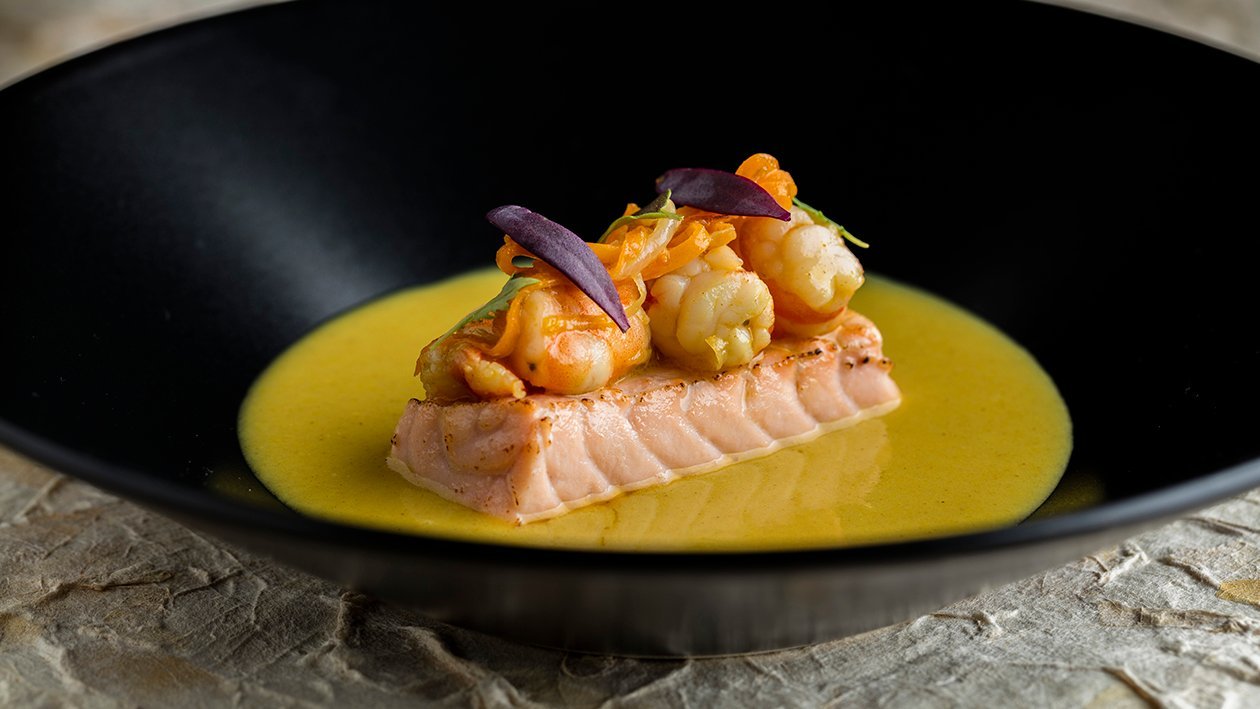 Salmón confitado con suave salsa de curry y guiso de langostinos Salmón confitado con suave salsa de curry y guiso de langostinos