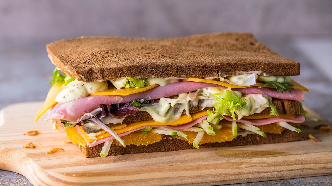 Sándwich de cheedar y jamón, ensalada fresca y mayonesa de salsa deluxe y cebolla crujiente Sándwich de cheedar y jamón, ensalada fresca y mayonesa de salsa deluxe y cebolla crujiente