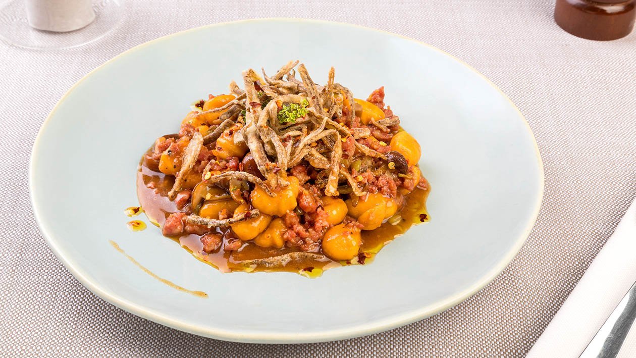 Gnocchetti di patate con ragù di capretto, funghetti chiodini, fiammiferi di cardi croccanti ed olio di peperone crusco – Ricetta Gnocchetti di patate con ragù di capretto, funghetti chiodini, fiammiferi di cardi croccanti ed olio di peperone crusco – Ricetta