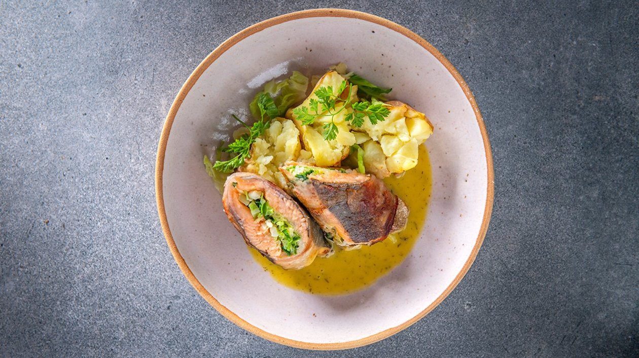 Rolletje van zalmforel met guanciale, savooikool, gepofte aardappel en picklessaus Rolletje van zalmforel met guanciale, savooikool, gepofte aardappel en picklessaus