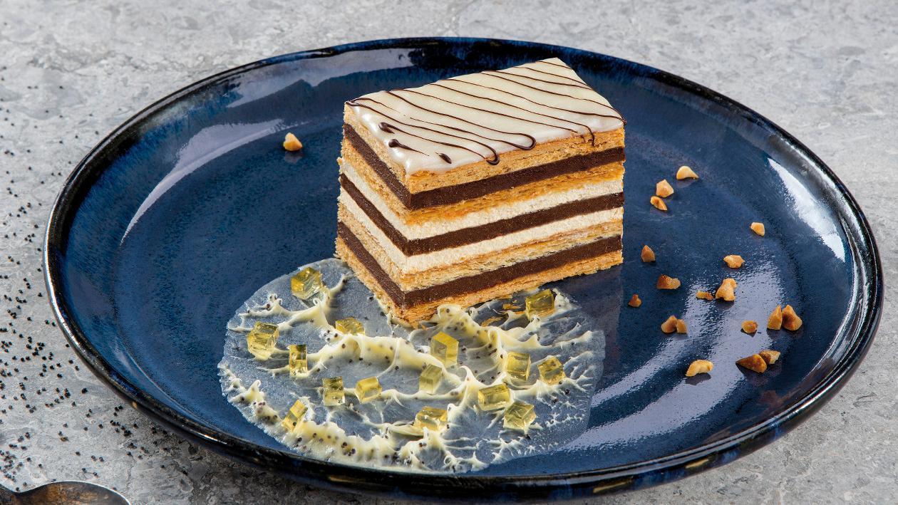Ciasto miodowe w odsłonie mille-feuille przeplatane masami czekoladowo-orzechową i śmietanową z ganache i galaretką miodową Ciasto miodowe w odsłonie mille-feuille przeplatane masami czekoladowo-orzechową i śmietanową z ganache i galaretką miodową
