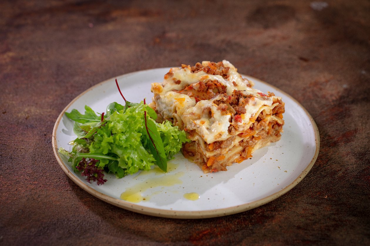 Lasagne wegatariańska z bukietem sałat i oliwą Lasagne wegatariańska z bukietem sałat i oliwą