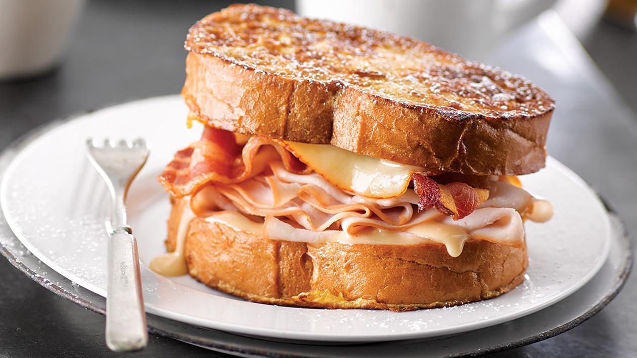 Tost francuski z szynką i serem, podany z sosem holenderskim Tost francuski z szynką i serem, podany z sosem holenderskim